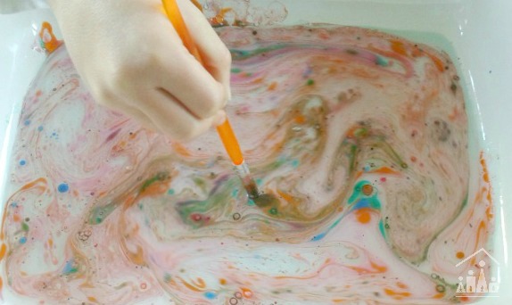 Swirling marbling inks in water to make Suminagashi art