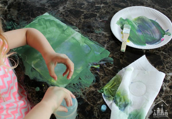 Preschooler creating a messy painting with water