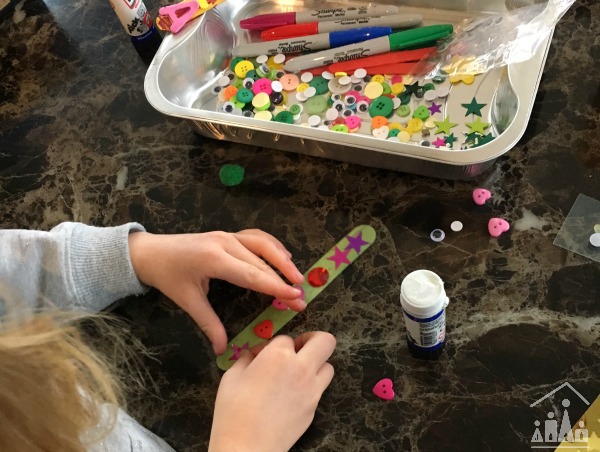 Child making a craft stick bookmark