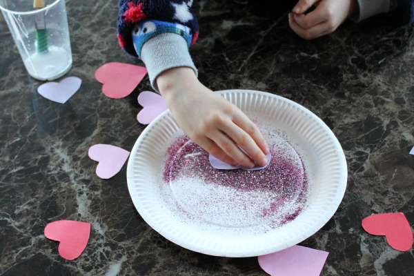 Covering hearts in glitter for a valentines day collage