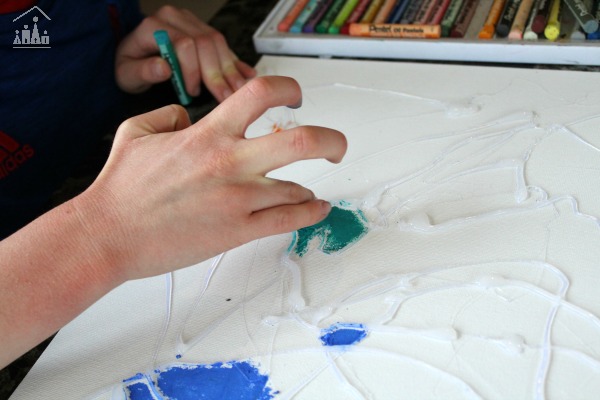 Child blending pastels on a glue resist art project