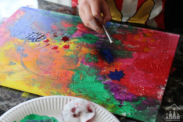 Child artist using q-tips on canvas