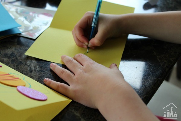 Kids using Easter stickers to decorate cards